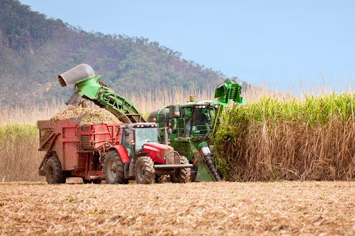 Trator trabalhando no campo com peças sem ferrugem em metais, projetado com materiais resistentes que reduzem a fadiga e minimizam tensões mecânicas, contribuindo para a durabilidade e eficiência do equipamento em condições exigentes.